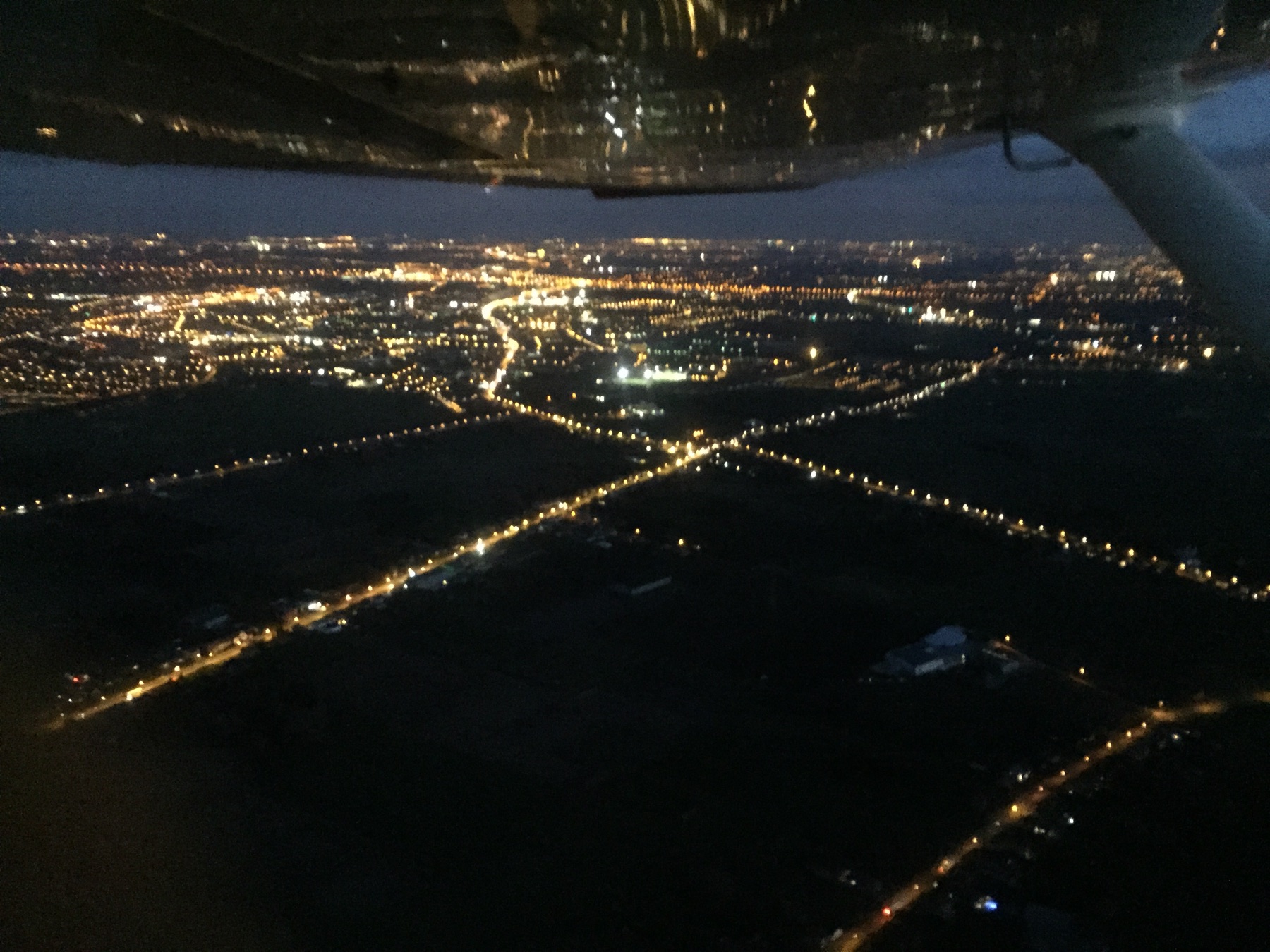 Stadslichten gezien vanuit een vliegtuig bij nacht